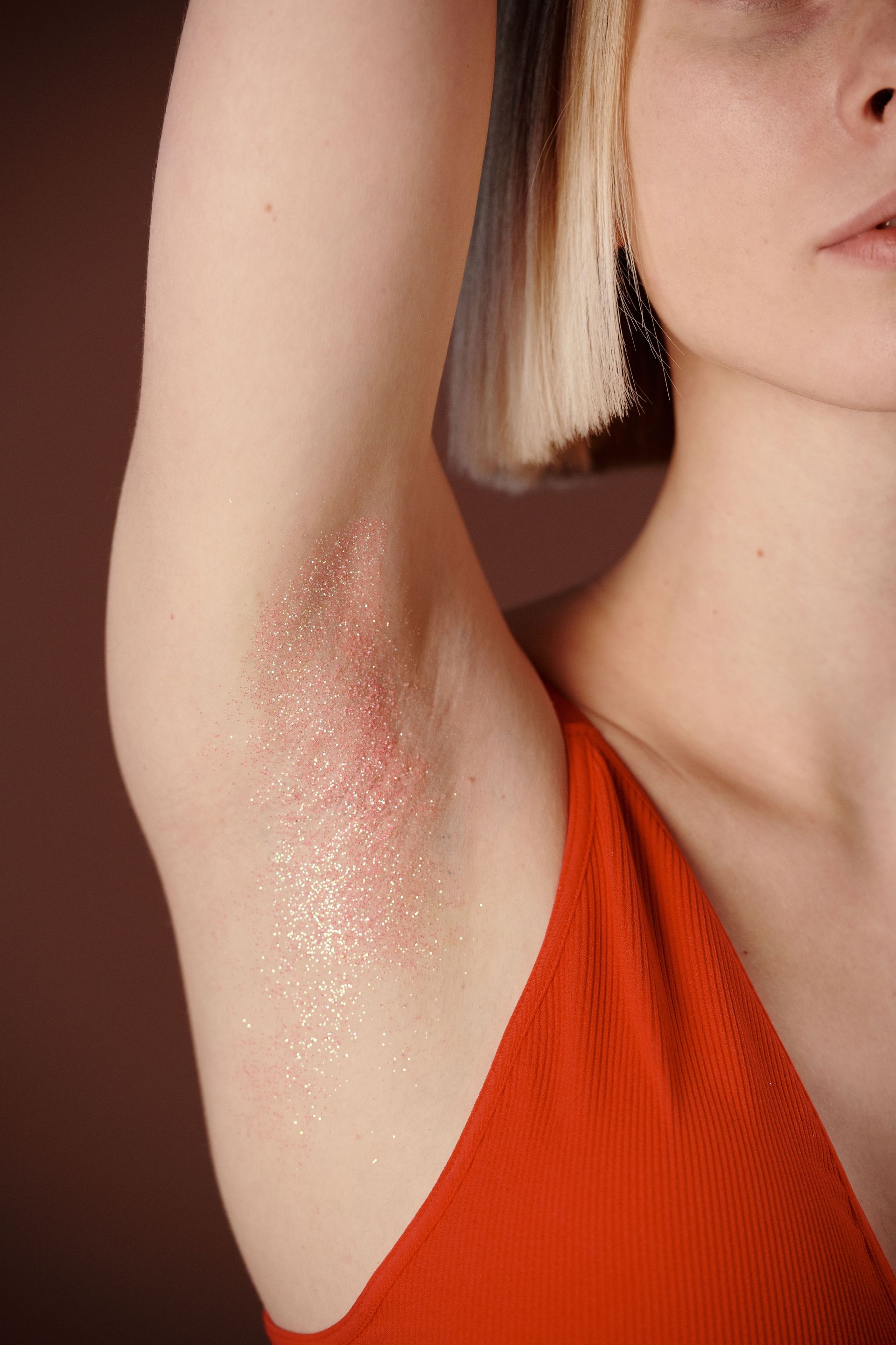 Artistic close-up of a woman's arm adorned with glitter, showcasing modern beauty and fashion.
